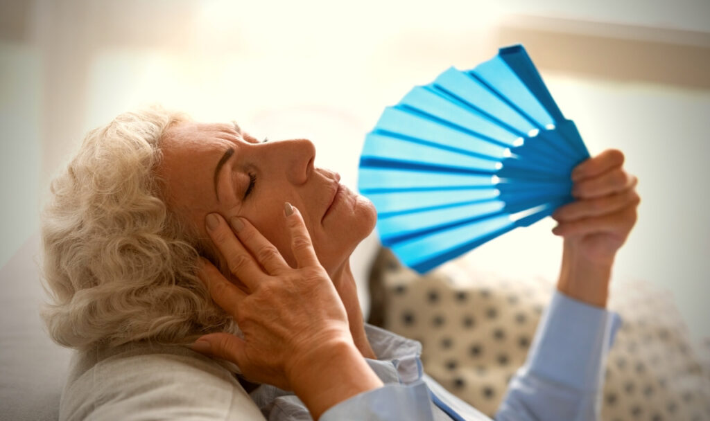 Senior woman with handheld fan